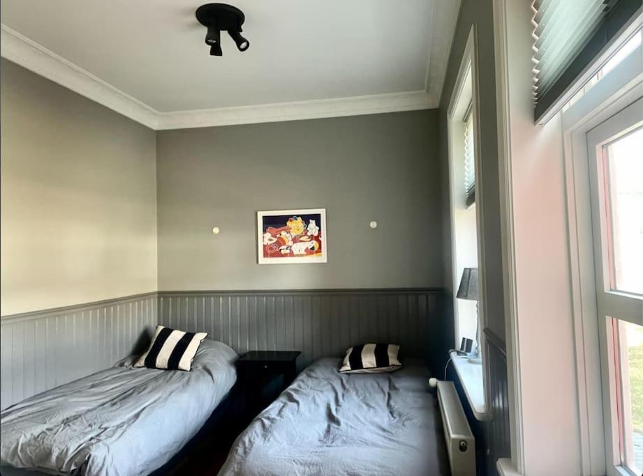 a bedroom with two beds and a window at The Foreman house - an authentic town center Villa in Húsavík