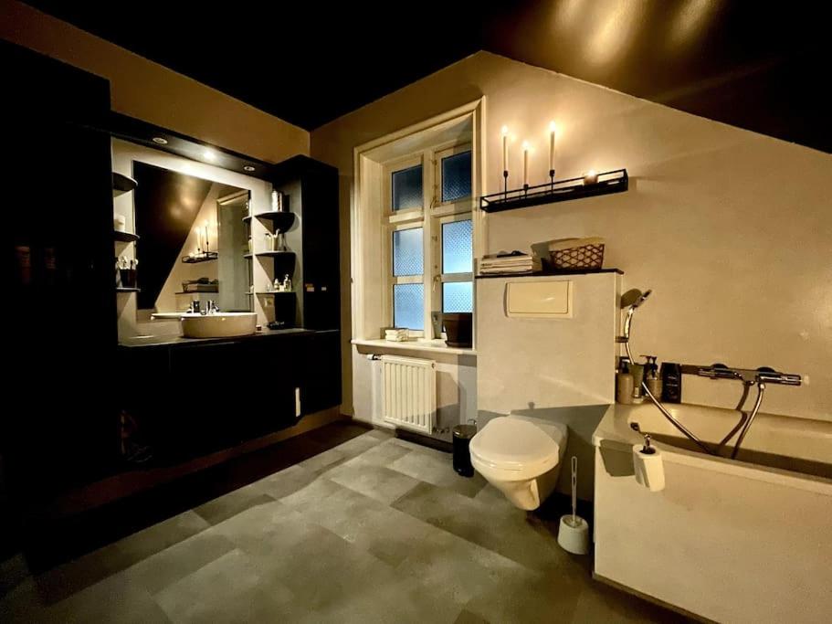 a bathroom with a toilet and a sink and a window at The Foreman house - an authentic town center Villa in Húsavík