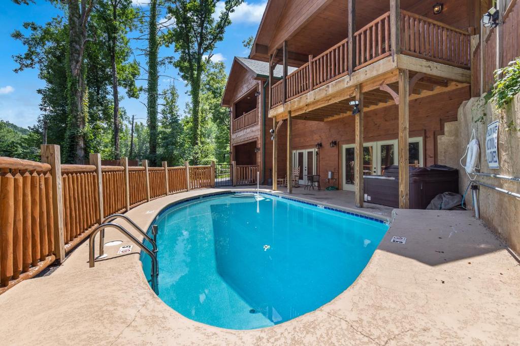 une maison avec une piscine en face d'une maison dans l'établissement Smoky Mountain Splash, 6 Bedroom, Private Pool, WiFi, Pool Table, Sleeps 18, à Gatlinburg