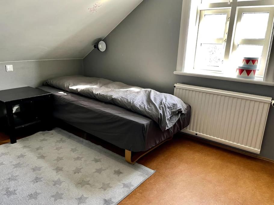 a bed in a room with a desk and a window at The Foreman house - an authentic town center Villa in Húsavík