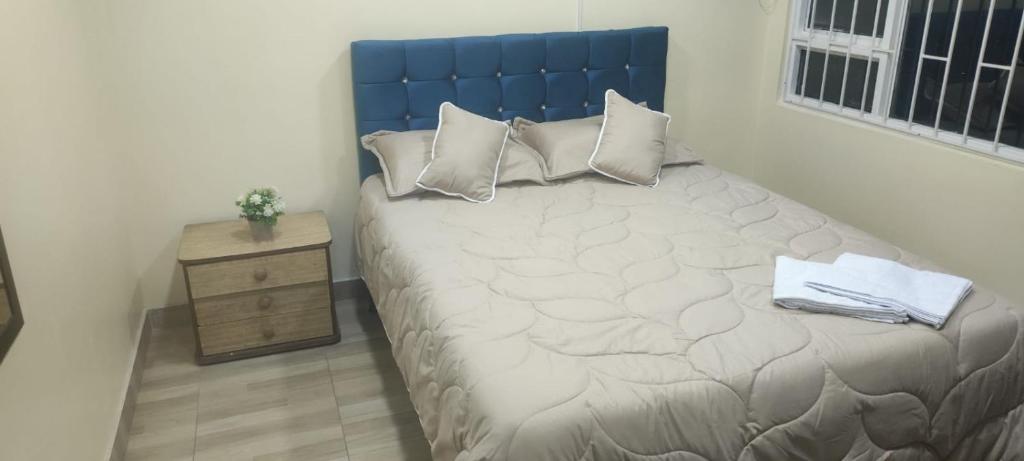 1 dormitorio con 1 cama grande y cabecero azul en Roma Lodges House- Campin Simón Bolivar Movistar Embajada compensar, en Bogotá