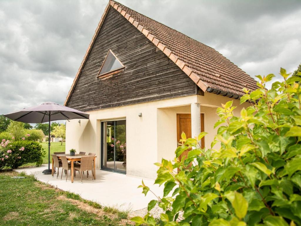 a small white house with a table and an umbrella at Lac Bleu 40 in Lacapelle-Marival