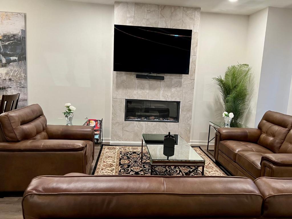 a living room with leather couches and a fireplace at Apple House- New Townhouse - 2 Car Garage by CCBC & Franklin Sq in Rosedale