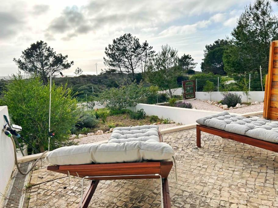 two benches sitting on top of a patio at Olive Tree Sunset View - V3 luxo vista mar in Aljezur