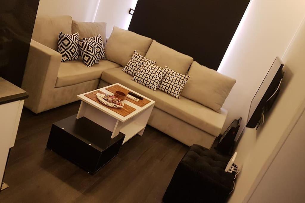 uma sala de estar com um sofá e uma mesa em ستوديو فندقي مع مسرح منزلي روعه وواي فاي em ‘Ezbet `Abd el-Ḥamîd