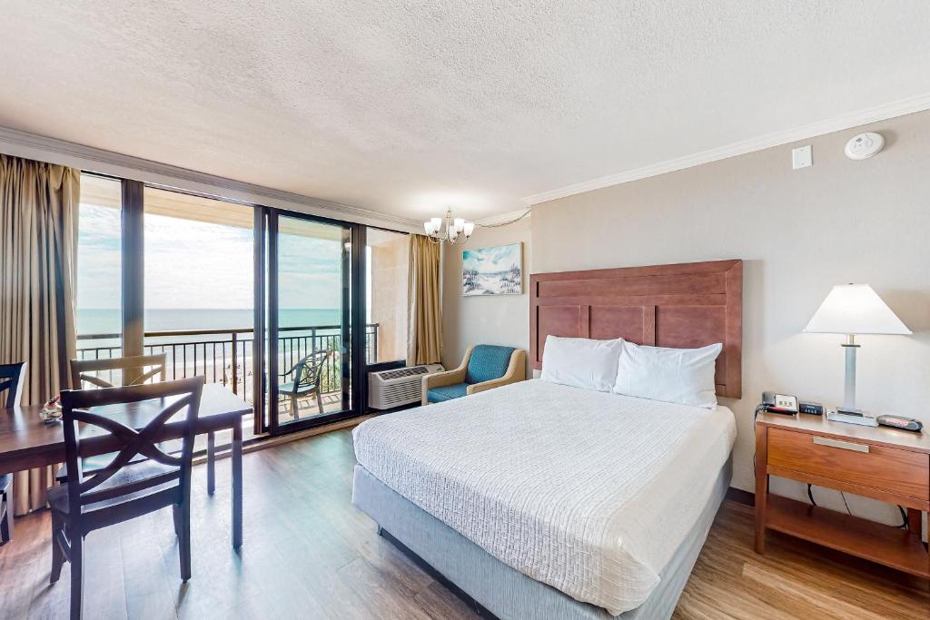 a hotel room with a bed and a desk with a desk at Ocean Blvd Studio, Unit 419 in Myrtle Beach