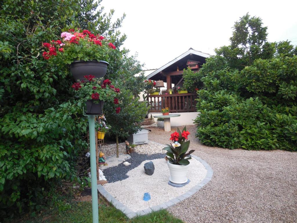 een tuin met bloemen op een paal met een vogelvoeder bij Gîte Saint-Dié-des-Vosges, 2 pièces, 2 personnes - FR-1-589-177 in Saint Die