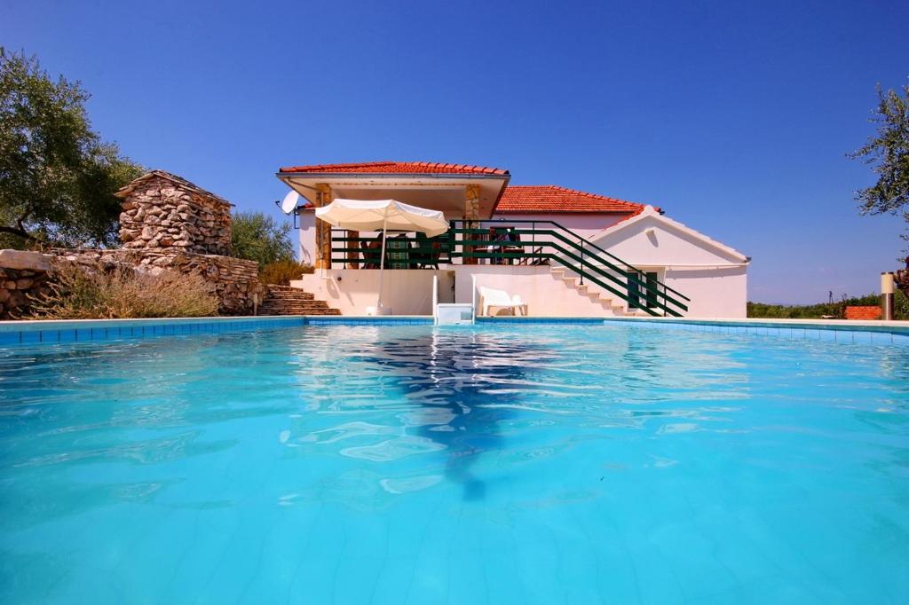 - une piscine en face d'une maison dans l'établissement Family friendly house with a swimming pool Cove Gradina, Korcula - 7552, à Vela Luka