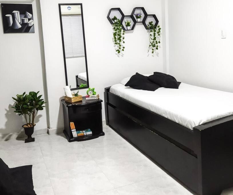 a bedroom with a black bed and a white floor at HABITACIÓN INDEPENDIENTE CERCA AL CENTRO in Santa Marta