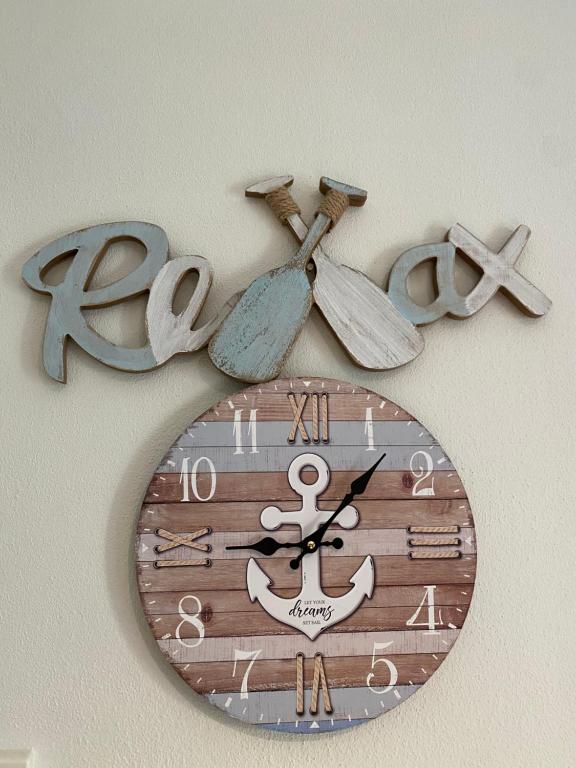 a clock hanging on a wall with scissors at A Berlenga 2 in Nazaré