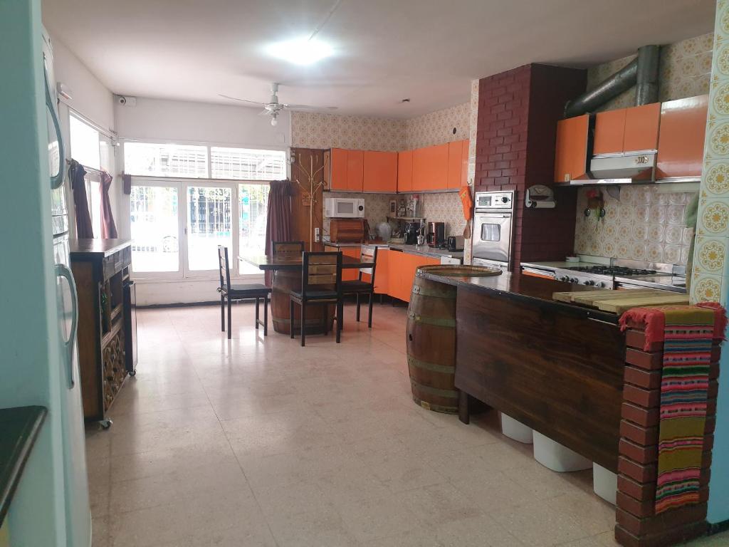 een keuken met oranje kasten en een eetkamer bij FourDoor in Guaymallen