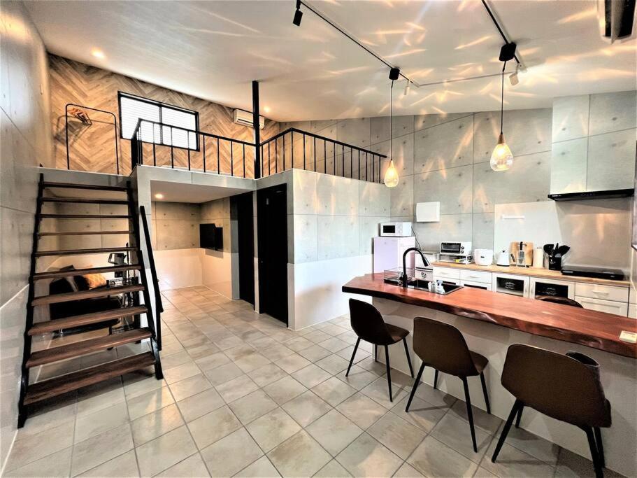 a kitchen with a staircase and a kitchen with chairs at とぅも～る in Ishigaki Island