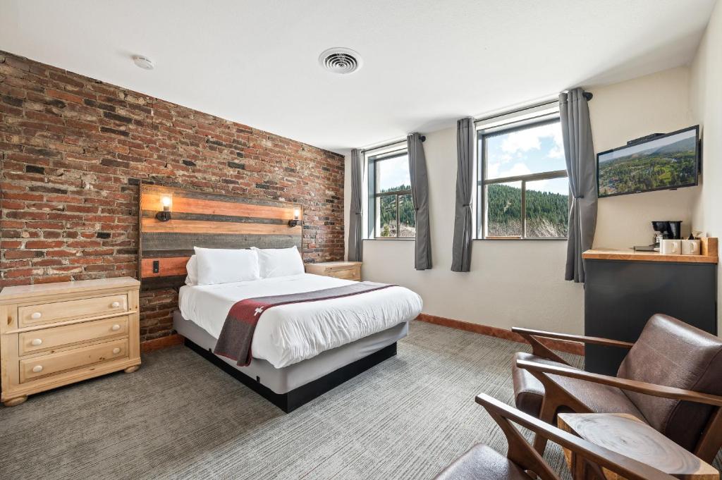 a bedroom with a bed and a brick wall at Hotel Leavenworth in Leavenworth