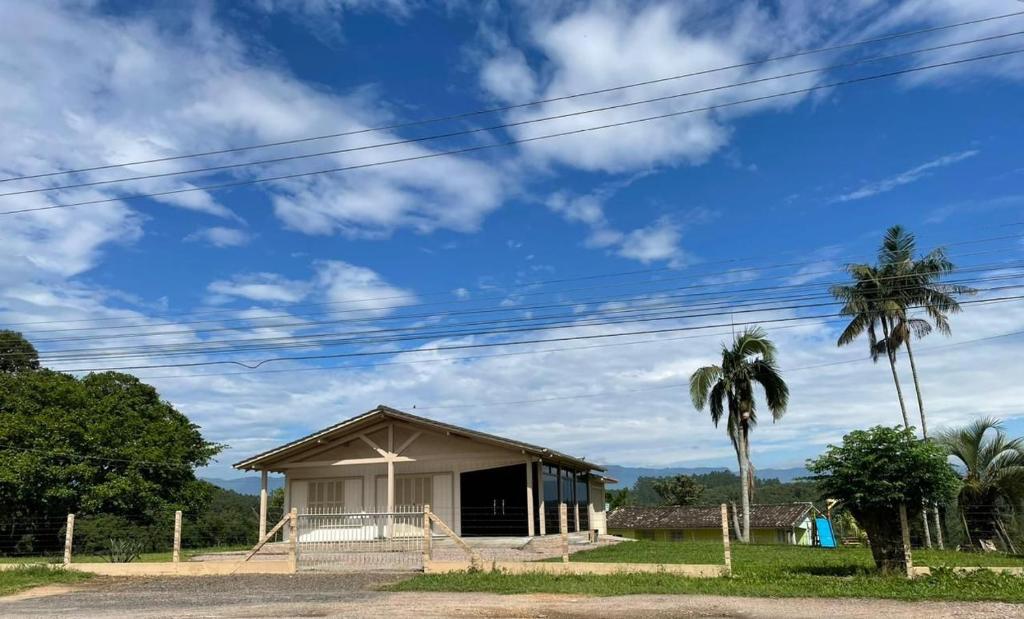 ein kleines Gebäude mit einer Palme und einem blauen Himmel in der Unterkunft Casa Benedet's in Lauro Müller