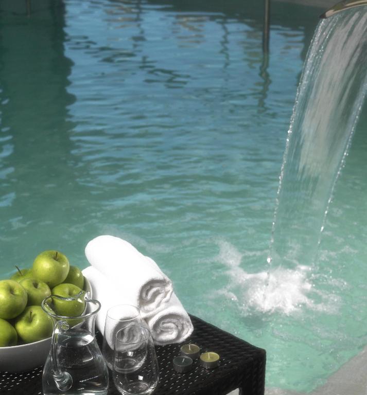 a table with a bowl of apples next to a swimming pool at Agua Hotels Riverside in Ferragudo