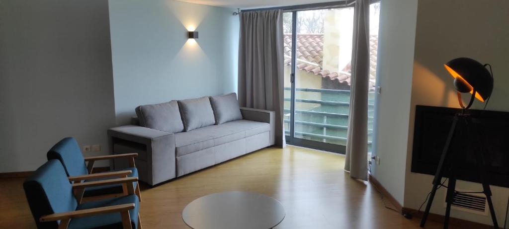 uma sala de estar com um sofá e uma mesa em Ponta Delgada Apartment T3 em Ponta Delgada