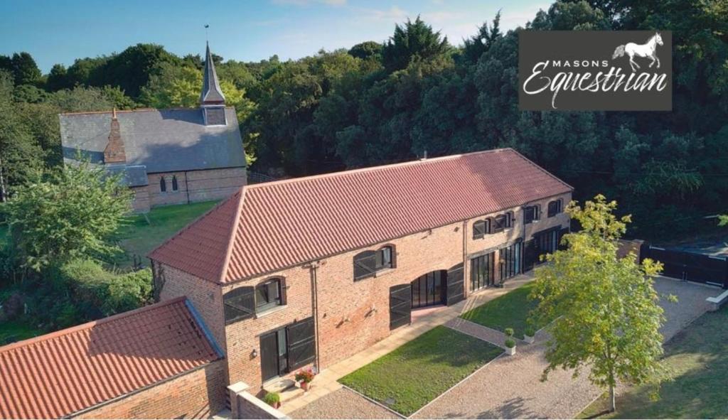 an overhead view of an old brick building with a church at Church Farm in Little Cawthorpe