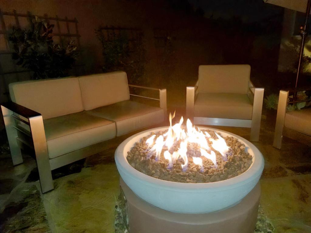 een vuurplaats in een woonkamer met een bank en stoelen bij Stunning, Quiet Pvt Luxe Home! King Bed, Hot Tub, Fire Pit, BBQ! Beautiful! in Los Angeles