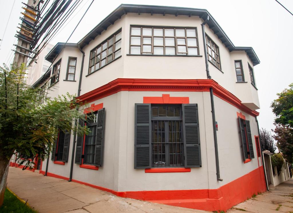 una casa blanca y roja con persianas negras en Casa Recreo, en Viña del Mar