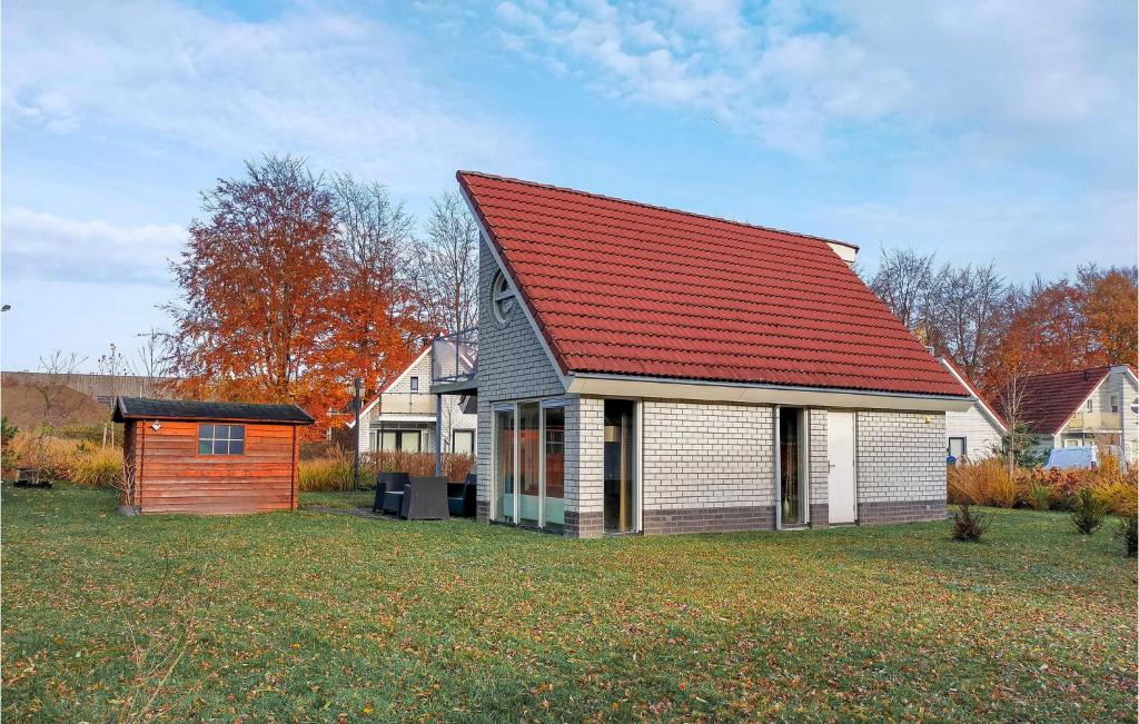 a house with a red roof on a yard at Beautiful Home In Delden With Sauna in Delden