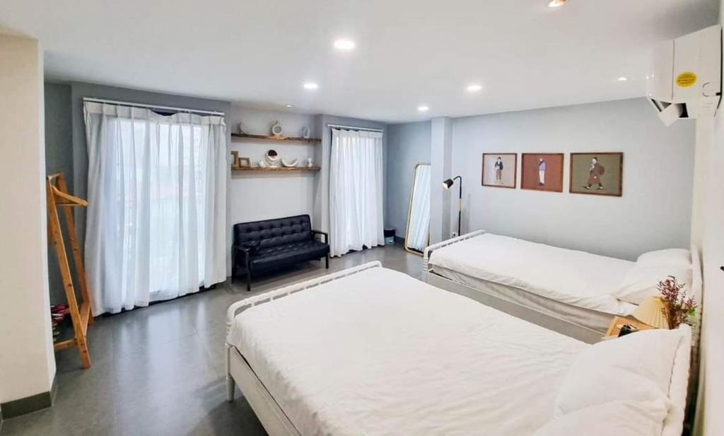 1 dormitorio con 2 camas y sofá en Lemon House en Quy Nhon