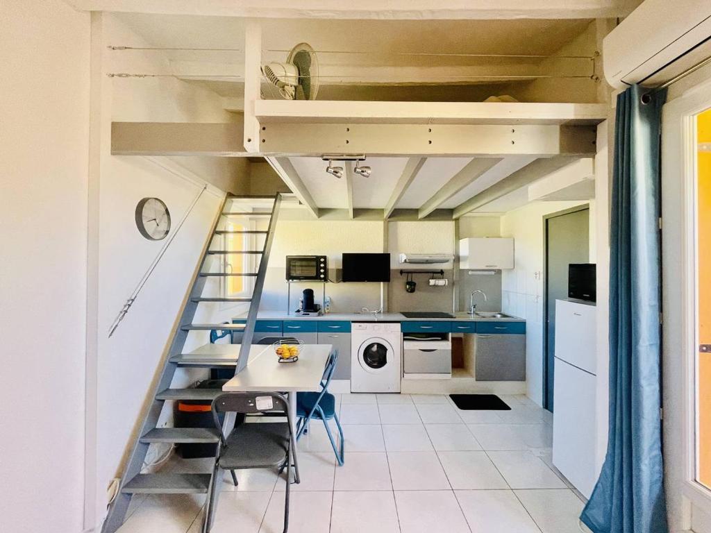 - une cuisine avec une mezzanine et une table dans une chambre dans l'établissement Studio moderne proche plage, climatisé, terrasse, parking inclus - Cap d'Agde - FR-1-723-98, au Cap d'Agde