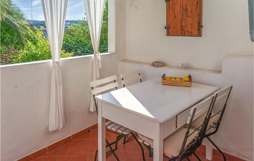 una mesa y sillas blancas en una habitación con ventana en Cozy Apartment In Mali Losinj With Kitchen, en Mali Lošinj