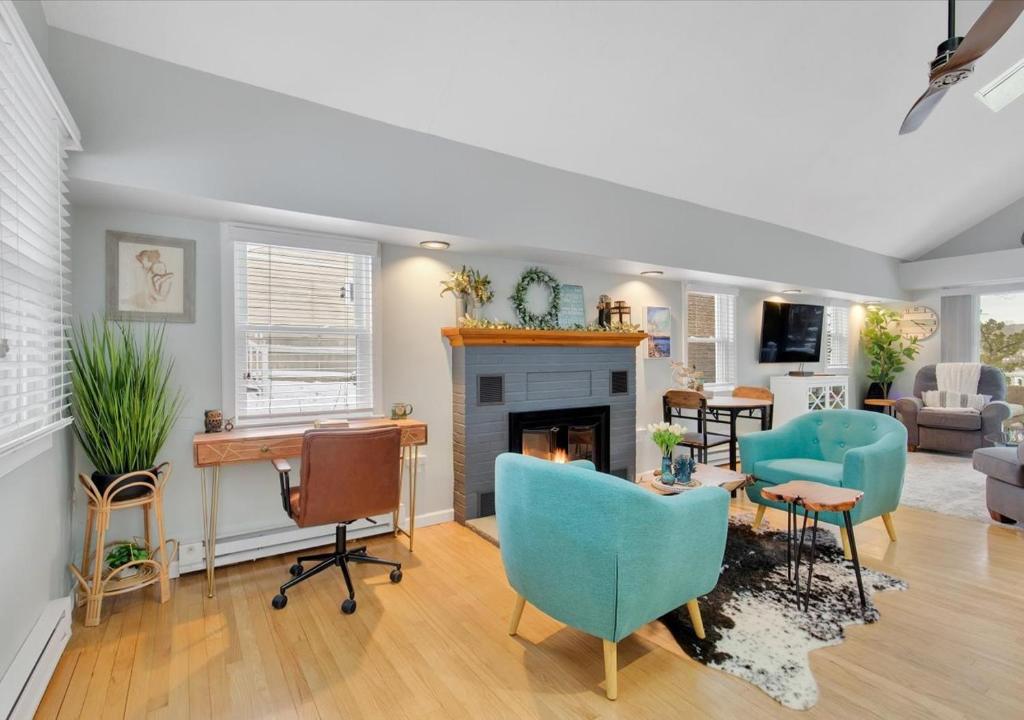 a living room with blue chairs and a fireplace at Sunset Cove in East Hampton