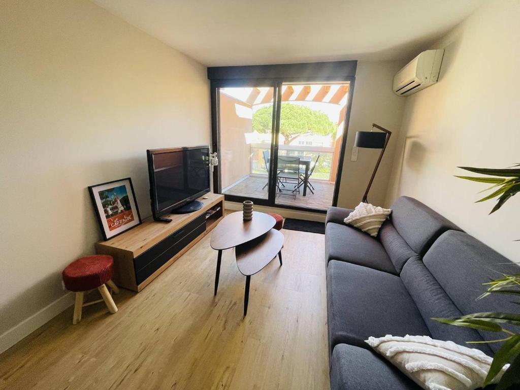 ein Wohnzimmer mit einem Sofa und einem Tisch in der Unterkunft Appartement Cap d'Agde, 4 pièces, 6 personnes - FR-1-723-78 in Cap d'Agde