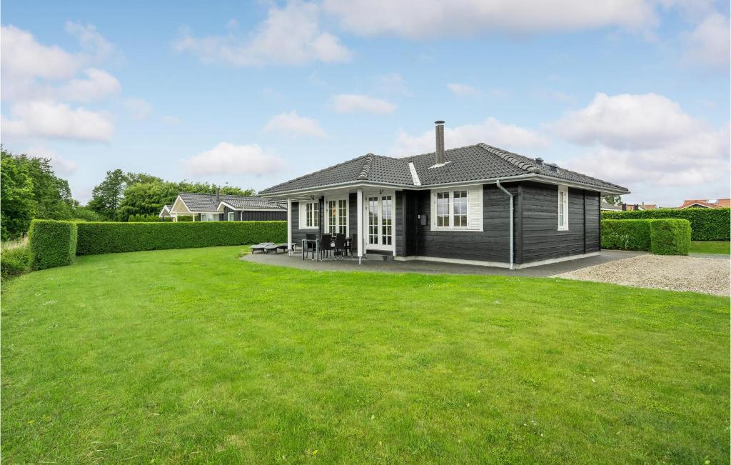 una casa con un gran césped delante de ella en Nice Home In Haderslev With 3 Bedrooms And Wifi, en Årøsund