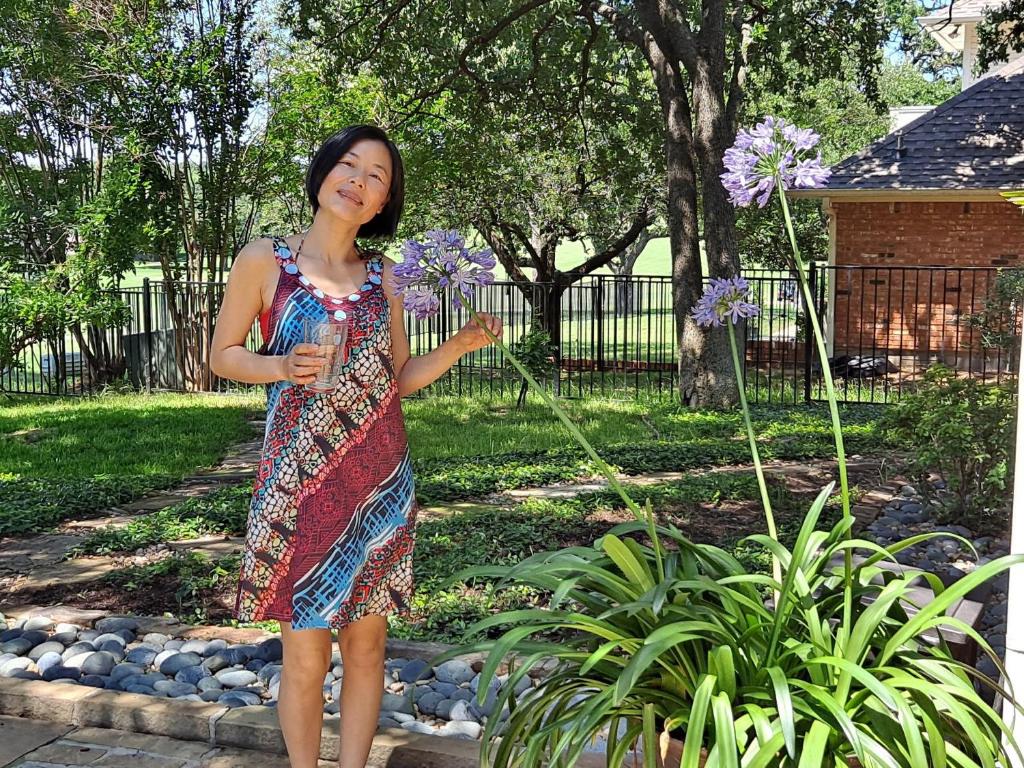 a woman in a dress holding purple flowers at Golden Sunflower's Apartment B1 in Lawton