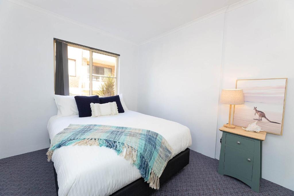 a white bedroom with a bed and a window at Haven Waters 3 in Forster