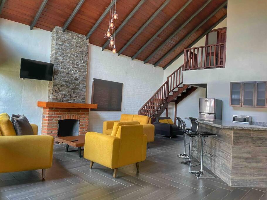 sala de estar con sillas amarillas y chimenea en Cabaña Familiar 05 en Mazamitla