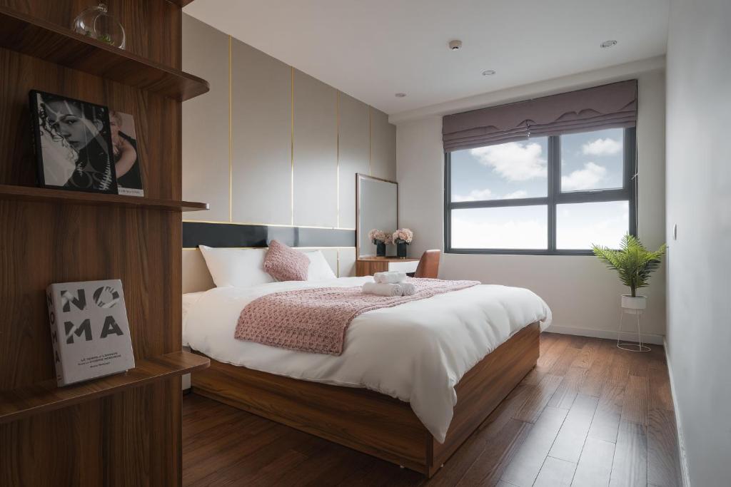 - une chambre avec un grand lit et une fenêtre dans l'établissement Troy House - Serviced Apartment - DCapitale, à Hanoï