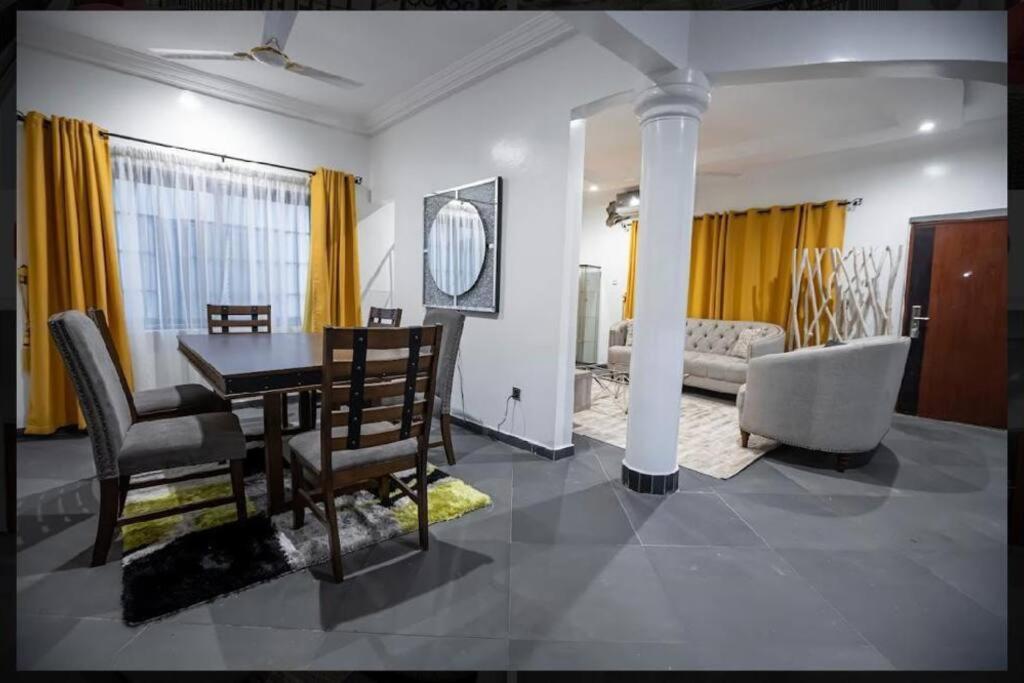 een eetkamer en een woonkamer met een tafel en stoelen bij Cozy penthouse ,Accra Ghana in Owuraman