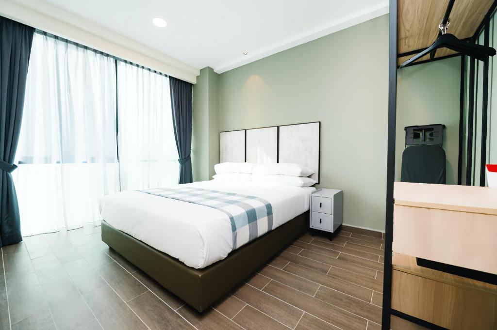 een slaapkamer met een bed en een groot raam bij Chill Suites Kuala Lumpur in Kuala Lumpur