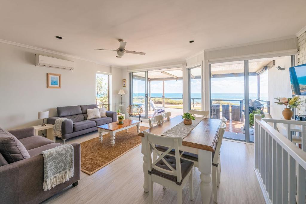 sala de estar con mesa y sofá en Port Willunga Ocean Views Beachhouse, en Port Willunga