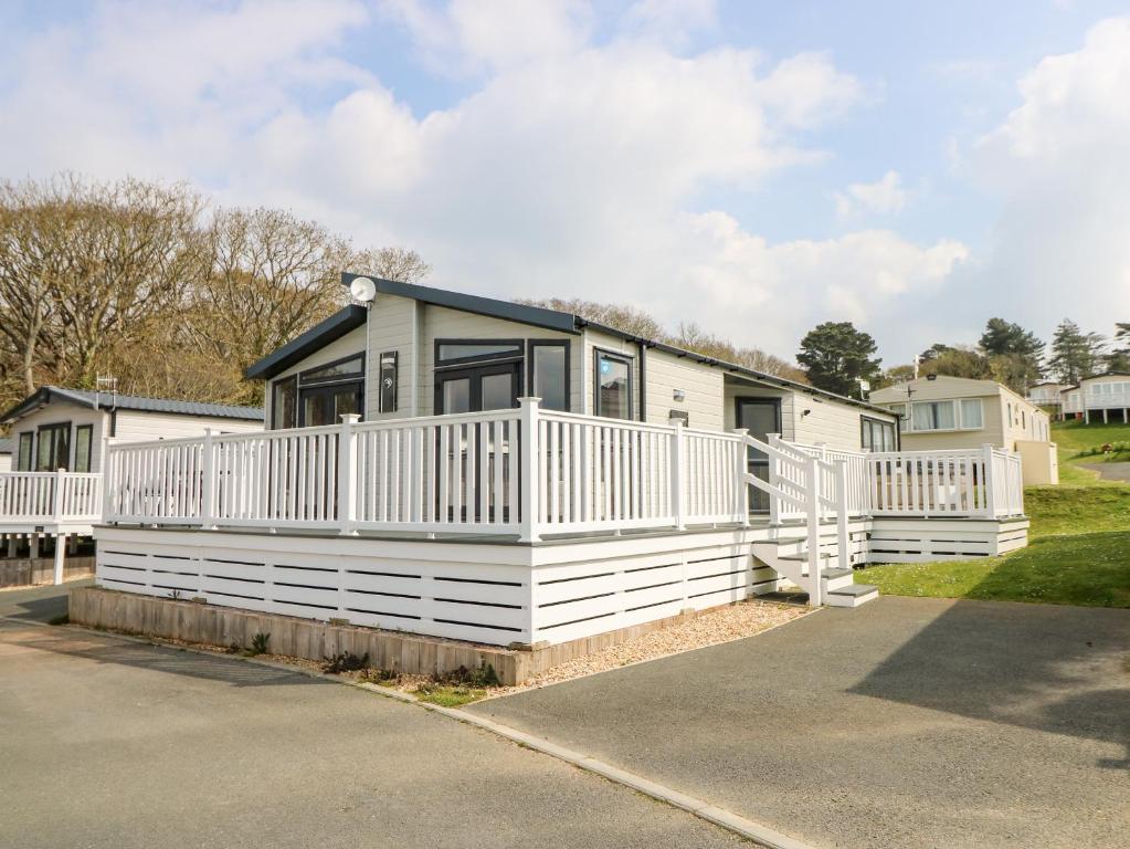 a white house with a porch and a driveway at Crosswinds 67 in Bembridge