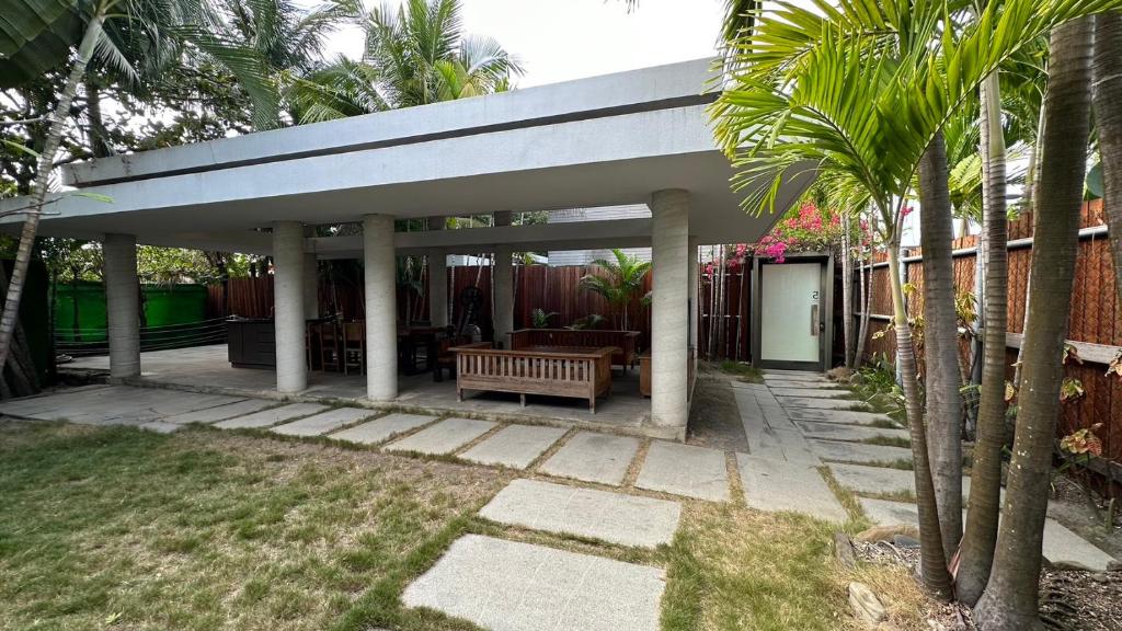 a pavilion with a bench in a yard with palm trees at Fu Wan Cafe Villa in Donggang