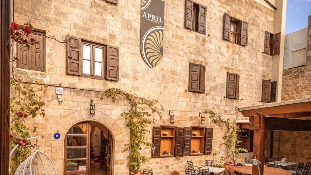 a large brick building with a table and chairs at APRIL Luxury Suites in Rhodes Town