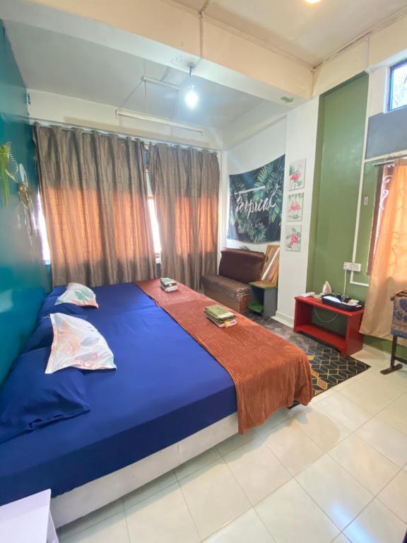 a bedroom with a blue bed and a couch at Pesona Backpackers Inn in Kota Bharu