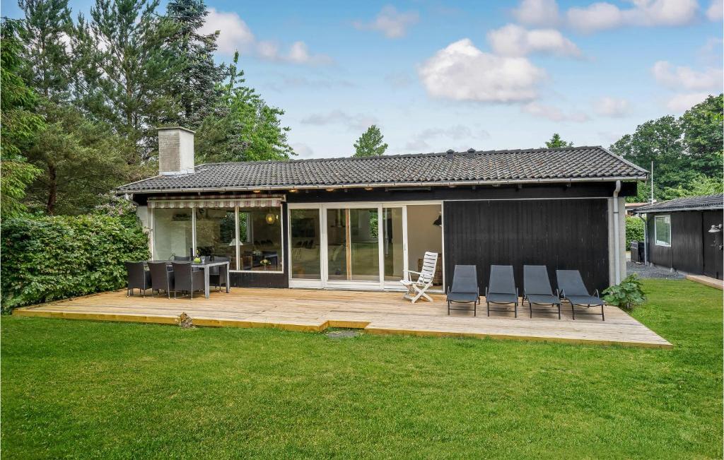 une maison avec une terrasse et des chaises dans la cour dans l'établissement Gorgeous Home In Jgerspris With Wifi, à Hornsved