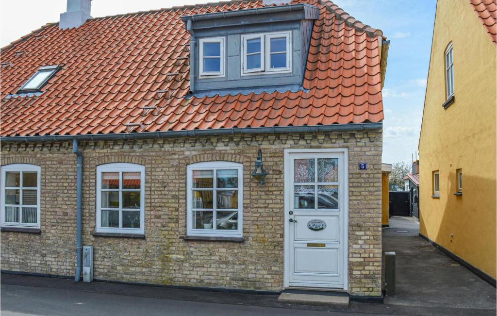 ein Backsteinhaus mit einem orangenen Dach und einer weißen Tür in der Unterkunft Nice Home In Sby With Kitchen in Sæby