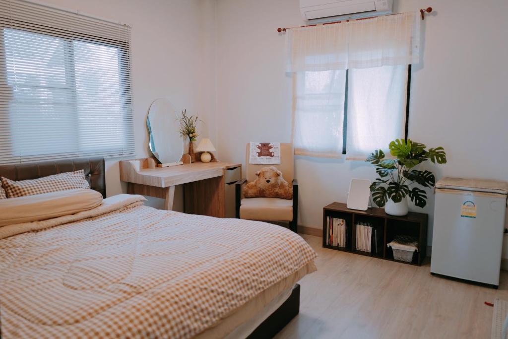 1 dormitorio con 1 cama y 1 silla en Nhunjai House - บ้านหนุนใจ, en Chiang Rai