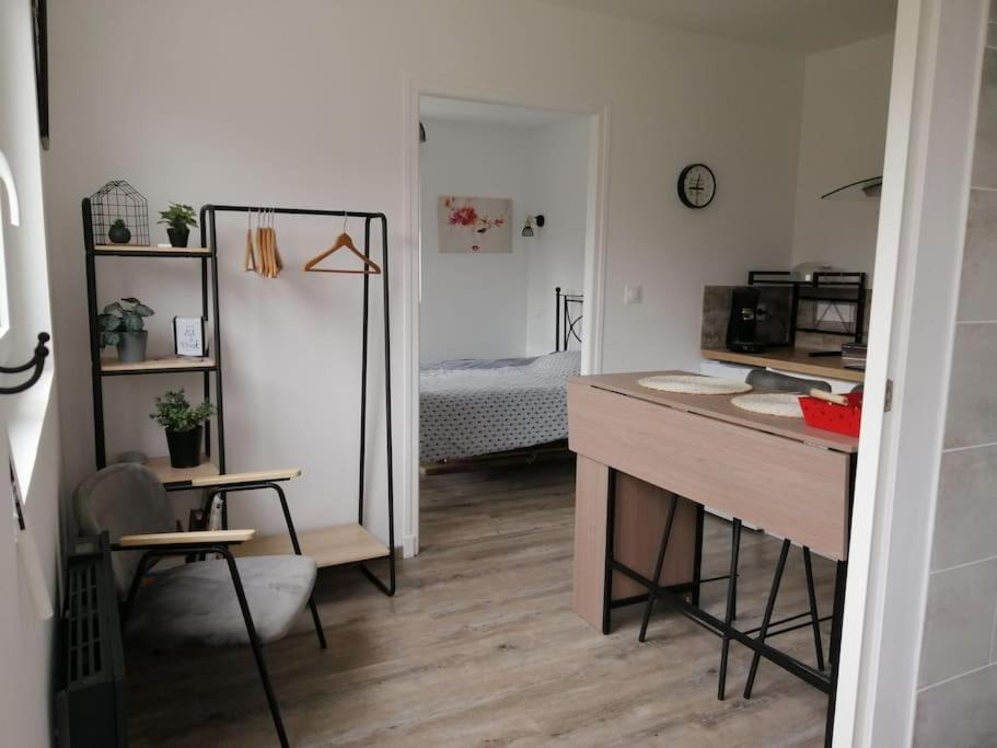 een kamer met een bureau en een slaapkamer met een bed bij Le petit Loir, gîte sur la Loire à vélo 