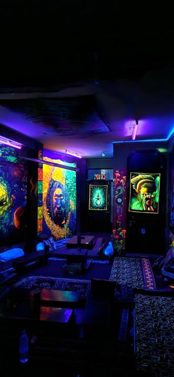 a room with several arcade games and purple lights at Parbati Headquarters in Kasol