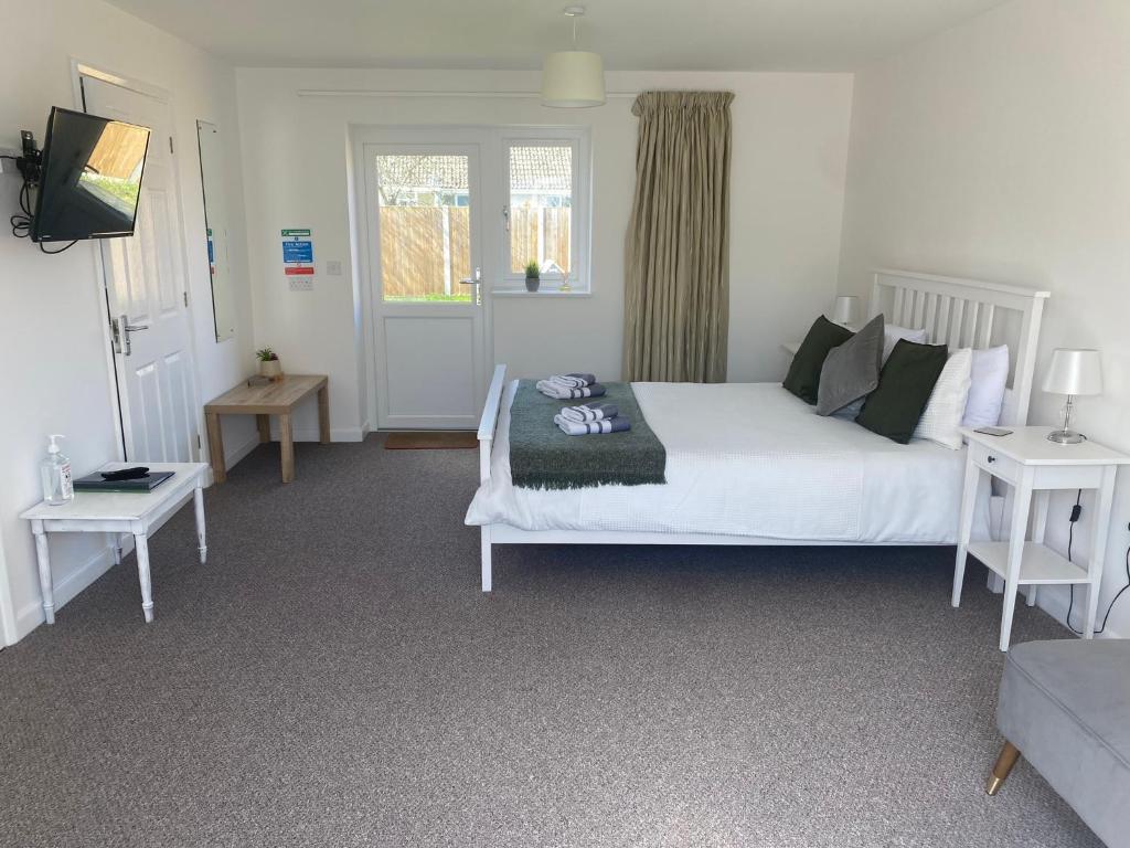 a bedroom with a large white bed and a couch at Number 7 - Lytton Tree Lodge, Reydon, Southwold in Reydon