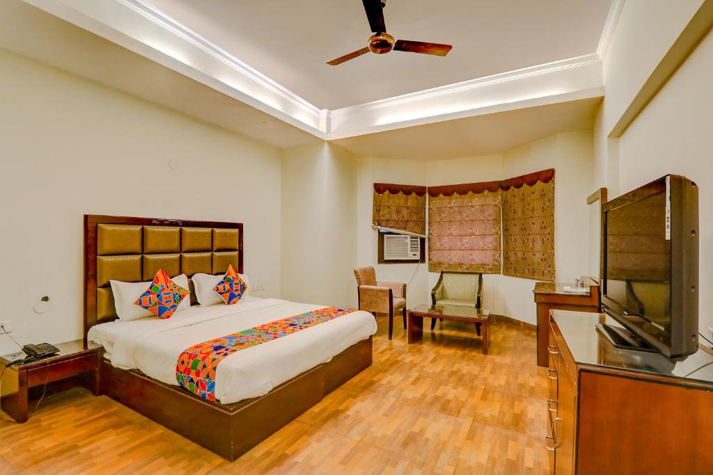 a bedroom with a bed and a flat screen tv at FabHotel Shimla Resort in Lucknow