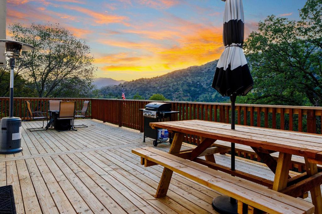 - une terrasse en bois avec un parasol et une table de pique-nique dans l'établissement Secluded Mountain Top Home Minutes to Sequoias & Kings Canyon, à Three Rivers