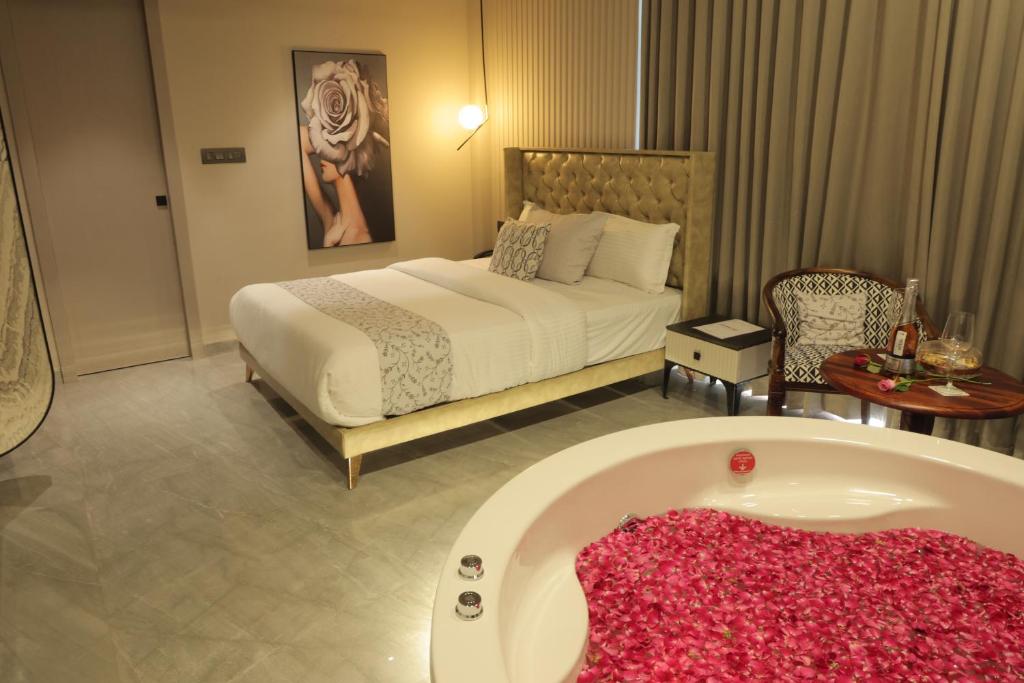 a bedroom with a bed and a bath tub at Apricot Motera in Ahmedabad